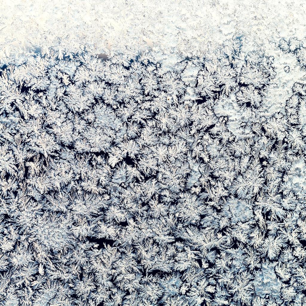 snowflakes and frost on frozen window pane