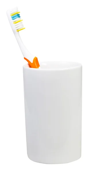 Un cepillo de dientes naranja en vidrio cerámico — Foto de Stock
