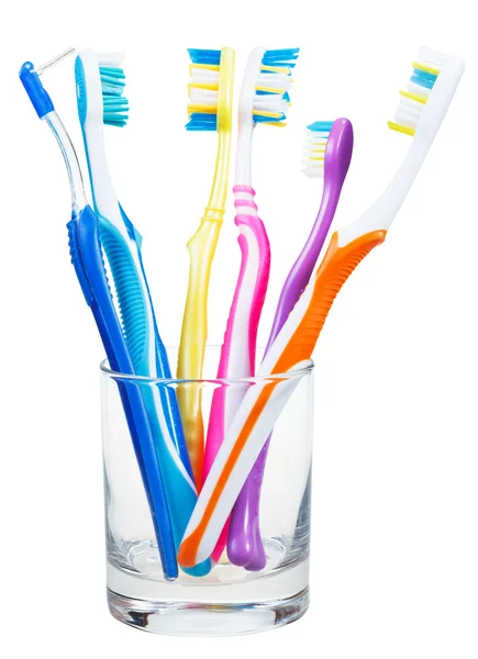 Toothbrushes and interdental brush in clear glass — Stock Photo, Image
