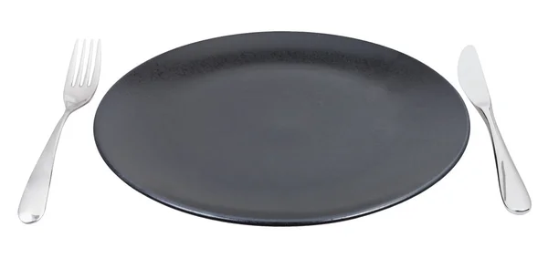 Пустая черная тарелка с вилкой и ножом изолированы — стоковое фото