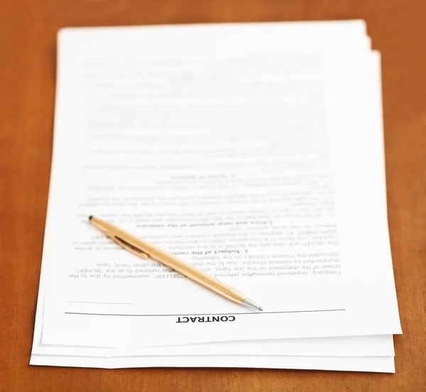 Sales contract and golden pen on wooden table — Stock Photo, Image