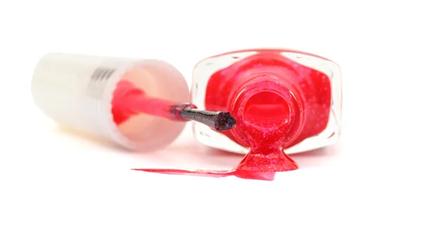 Flasche mit verschüttetem rosa Nagellack auf weißem Grund — Stockfoto