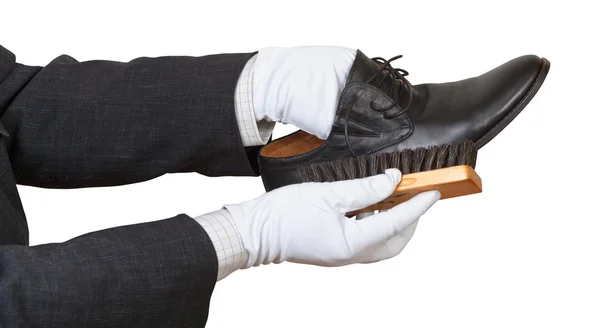 Shoeshiner in white gloves brushing black shoe — Stock Photo, Image