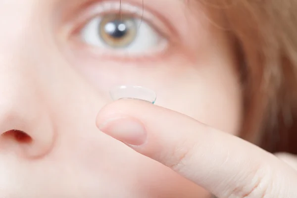 Finger with contact lens near woman's face — Stock Photo, Image