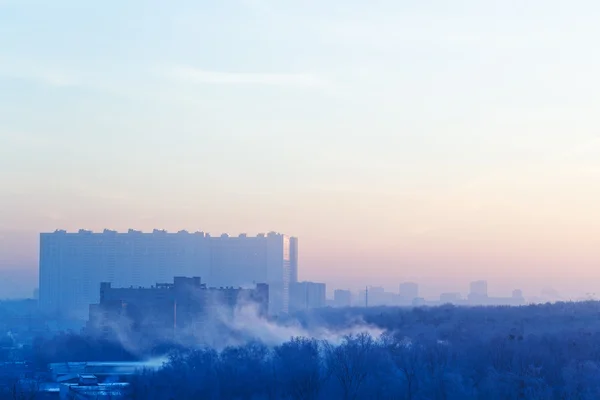 Brouillard levant et ciel bleu et rose au-dessus de la ville — Photo