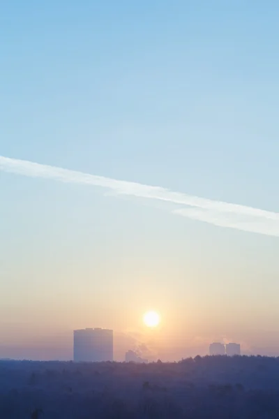 Sunrise solen i blå himmel över staden i kalla vintern — Stockfoto