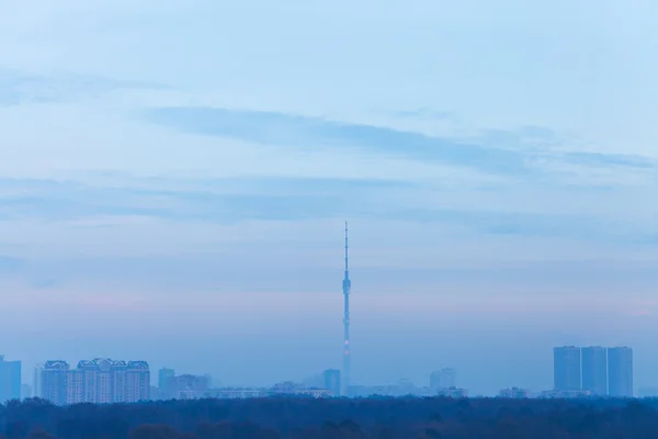 Сутінкове блакитне небо над містом з телевежею — стокове фото