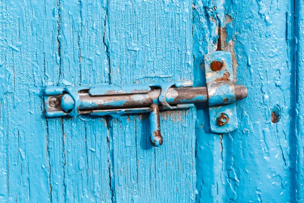 Espagnolette sur vieille porte bleue peinte — Photo