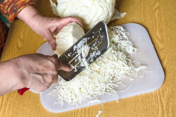 Woman shredding cabbage on cutting board — Stock Photo, Image