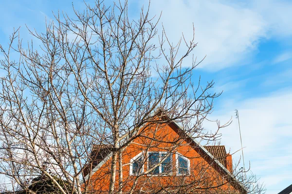 Niebieski niebo i cegła dom wsi wiosną — Zdjęcie stockowe