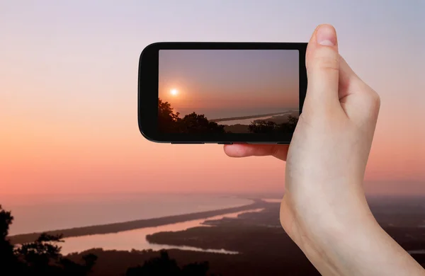 Toeristische nemen foto van zoutmeer bij roze zonsondergang — Stockfoto