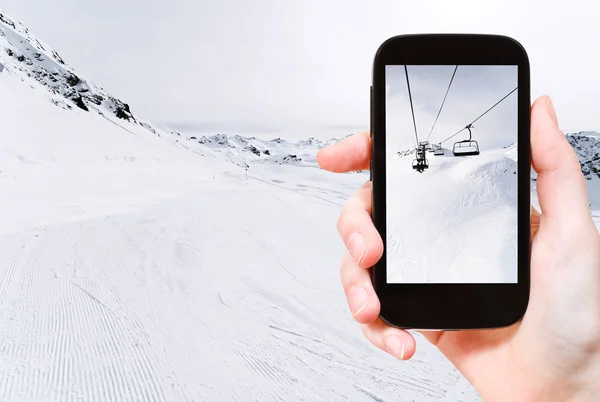 Toeristische nemen foto van skiën tracks en ski lift — Stockfoto
