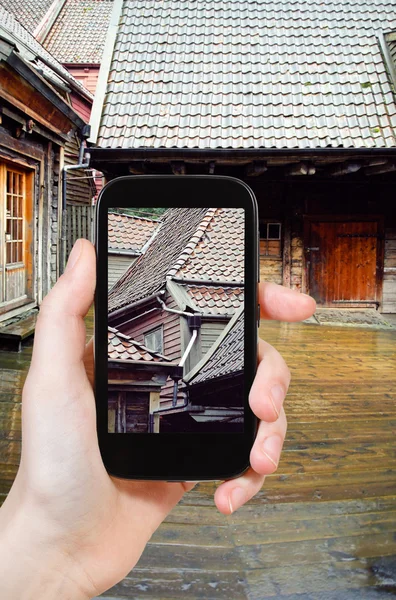 Toeristische nemen foto van houten huizen, Bergen — Stockfoto