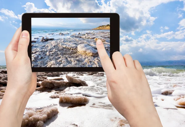 Tourist taking photo of crystal salt on Dead Sea — Stock Photo, Image