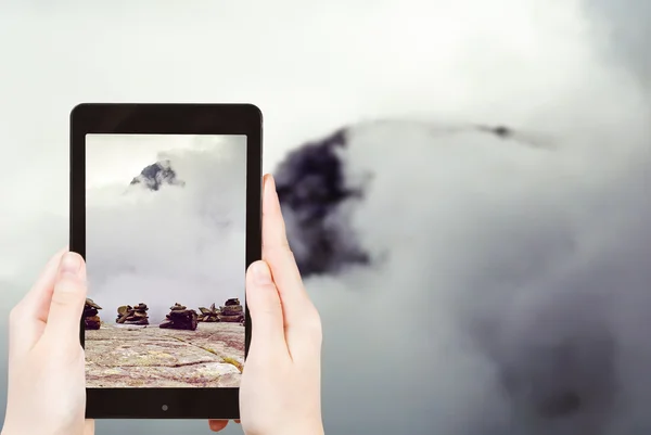 Tourist taking photo of stone pyramid in mountain — Stock Photo, Image