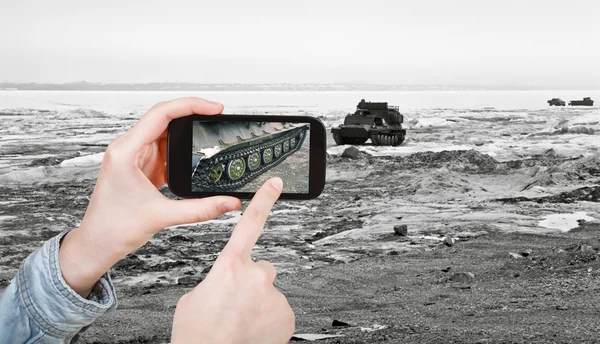 Turista tomando foto vehículo rastreado en la carretera de hielo —  Fotos de Stock