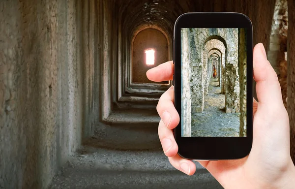 Toeristische nemen foto van oude arcades in tempel — Stockfoto