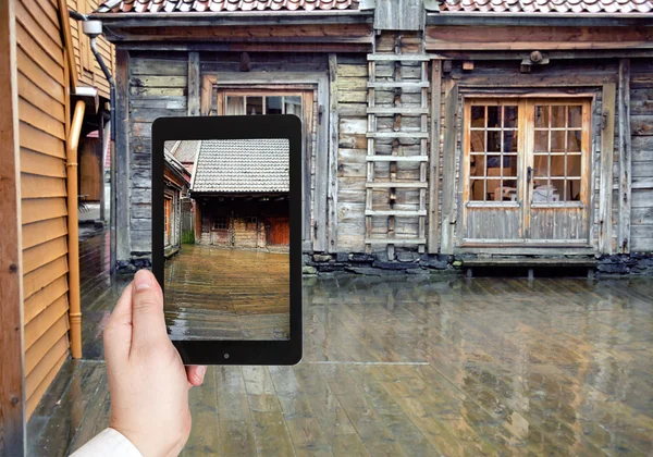 Toeristische nemen foto van houten trottoir in regen — Stockfoto