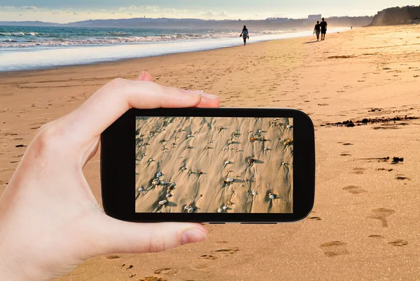 Toeristische nemen foto van zand strand close-up — Stockfoto