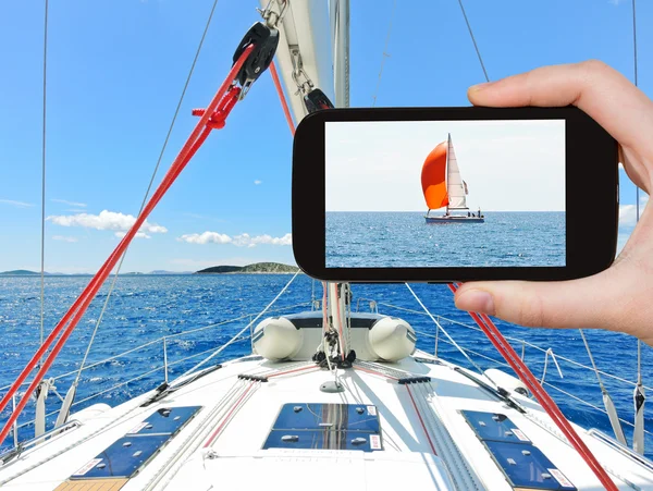 Tourist taking photo of red yacht in Adriatic sea — Stock Photo, Image