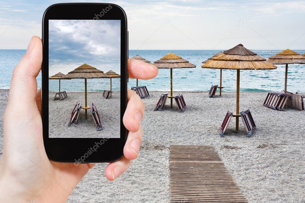 tourist taking photo of empty Ionian sea beach