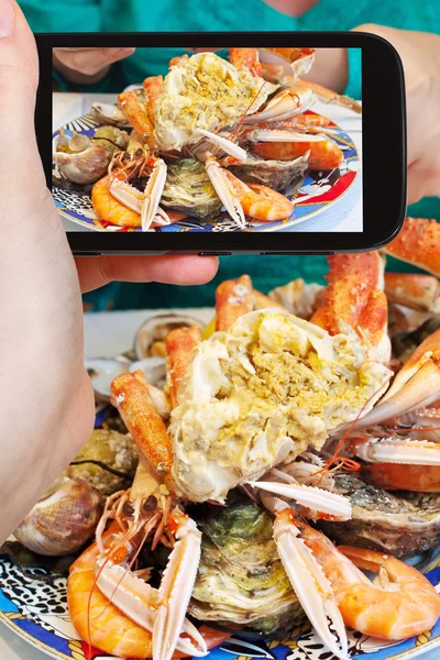 Tourist photographs of plate with crab and seafood — Stock Photo, Image