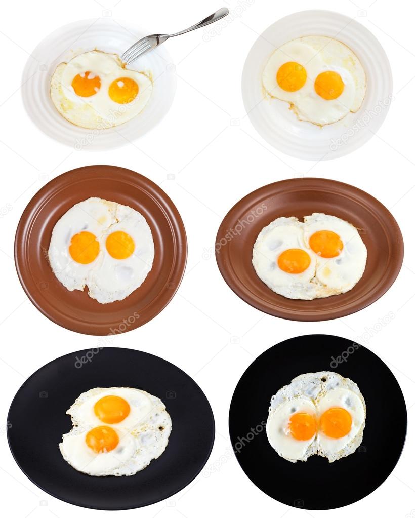 set from two fried eggs on plates isolated
