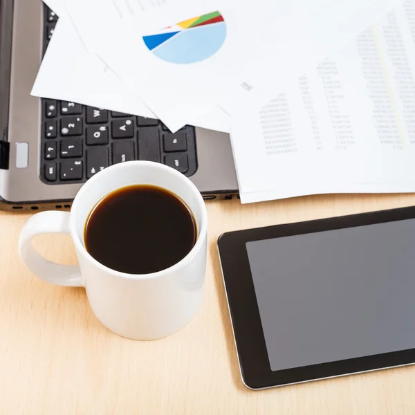 Mug of coffee and tablet pc on office table — Stock Photo, Image