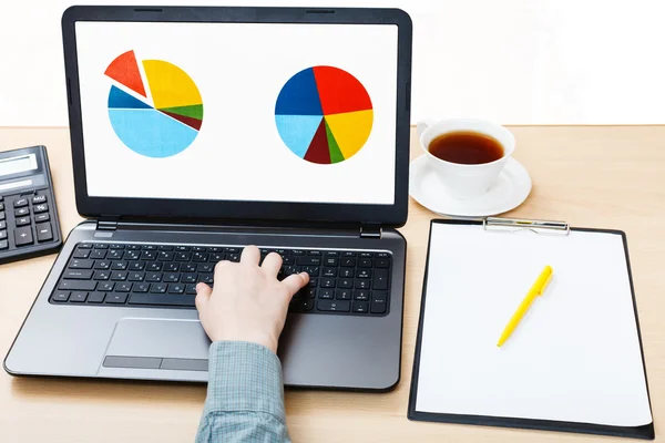 Laptop with chart on screen on office desk — Stock Photo, Image