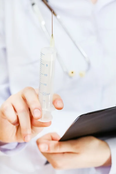 Nurse holds syringe and clipboard — Stock Photo, Image