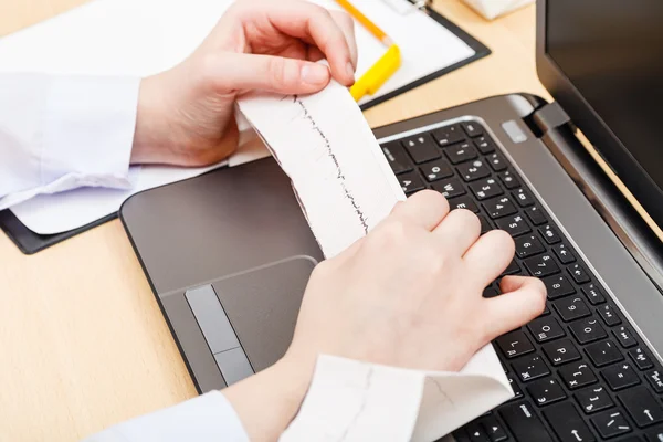 Doctor examines patient electrocardiogram — Stock Photo, Image