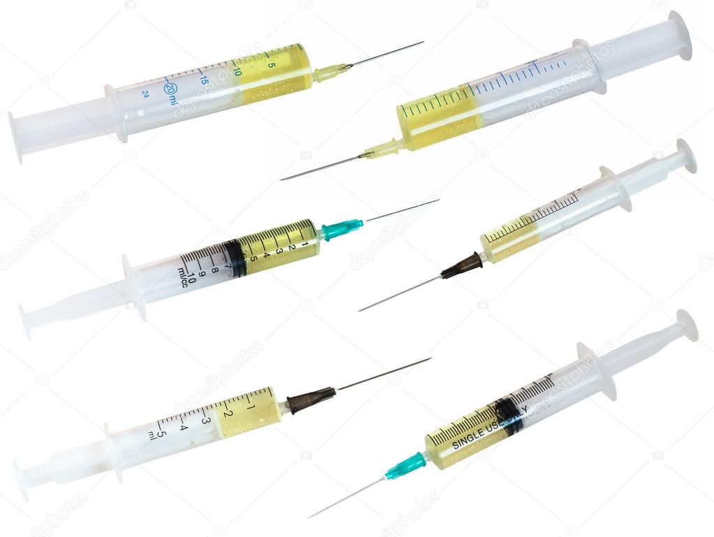 set of syringes filled with yellow liquid isolated