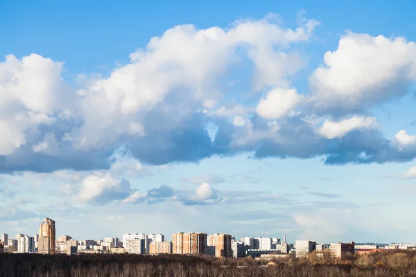 Clouds in blue spring sky over city — Stock Photo, Image