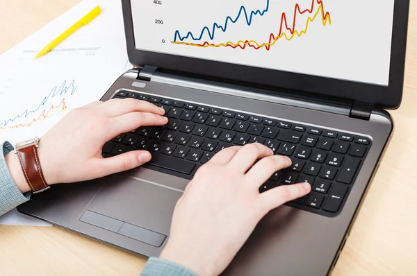 dizüstü bilgisayar ve grafik ekranında tablo üzerinde çalışan