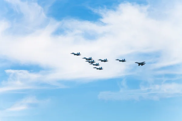 Летят военные истребители в белых облаках — стоковое фото