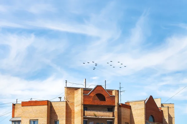 Военные истребители и штурмовики над домом — стоковое фото