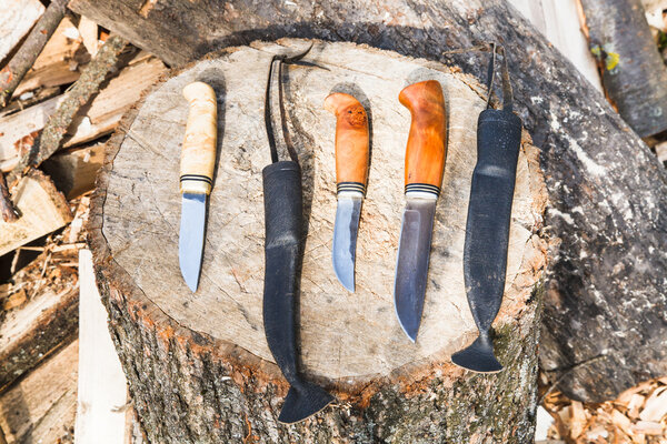 hunting knives on wooden stump