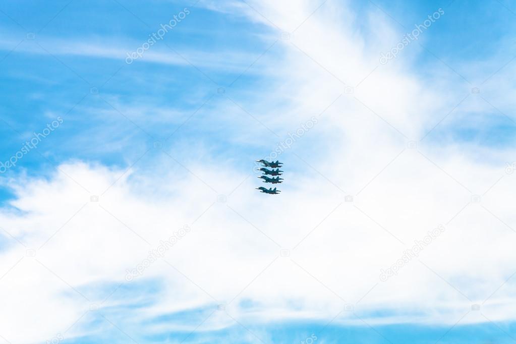 four military fighter aircrafts in white clouds