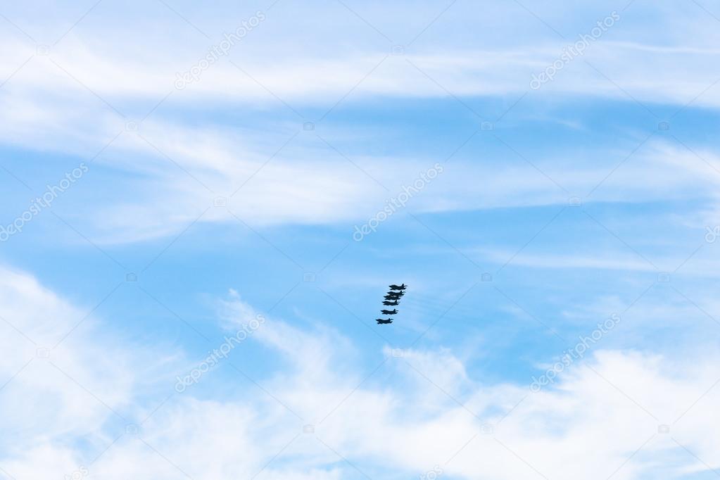 blue sky with clouds and military fighter aircraft