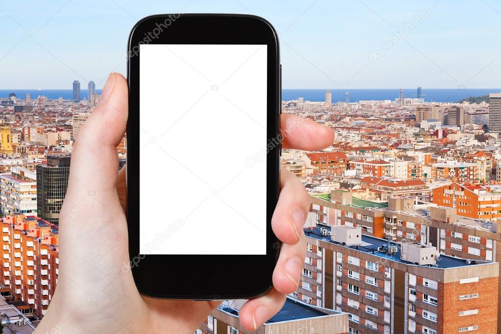 Travel concept - tourist photograph above view of living district in Barcelona, Spain in evening on smartphone with cut out screen with blank place for advertising logo