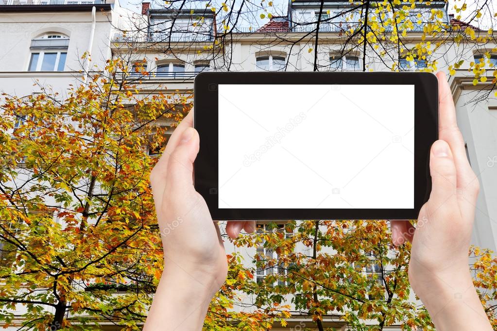 Travel concept - tourist photograph facade of urban mansion of the 19th century on Fasanenstrasse in Berlin in autumn on tablet pc with cut out screen with blank place for advertising logo