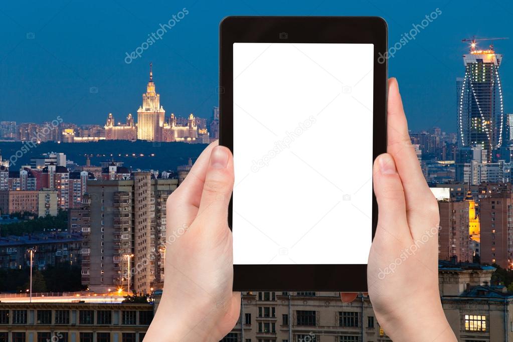 Travel concept - tourist photograph Moscow city skyline at dusk in summer night , Russia on tablet pc with cut out screen with blank place for advertising logo