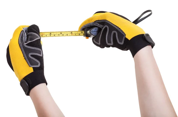 Hands in protective gloves with tape measure — Stock Photo, Image