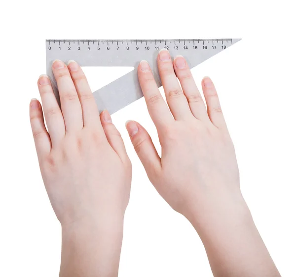 Female hands with metallic triangle ruler — Stock Photo, Image
