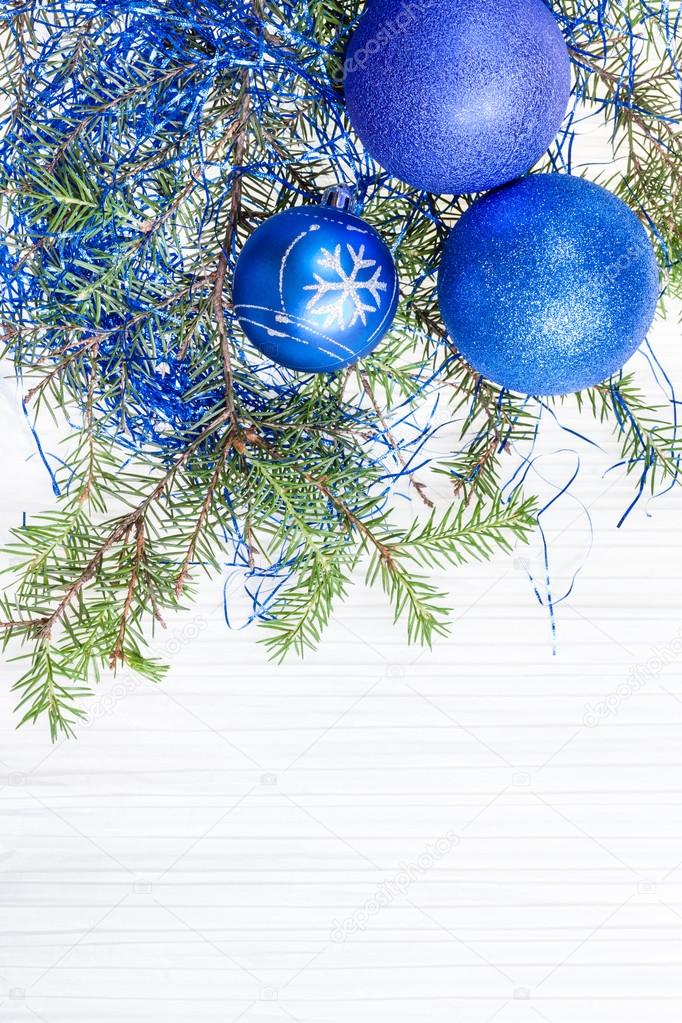 three blue and violet Xmas balls and twig on paper