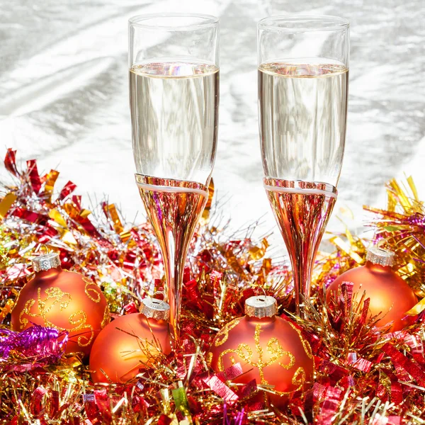 Glasses of sparkling wine with gold Xmas baubles — Stock Photo, Image