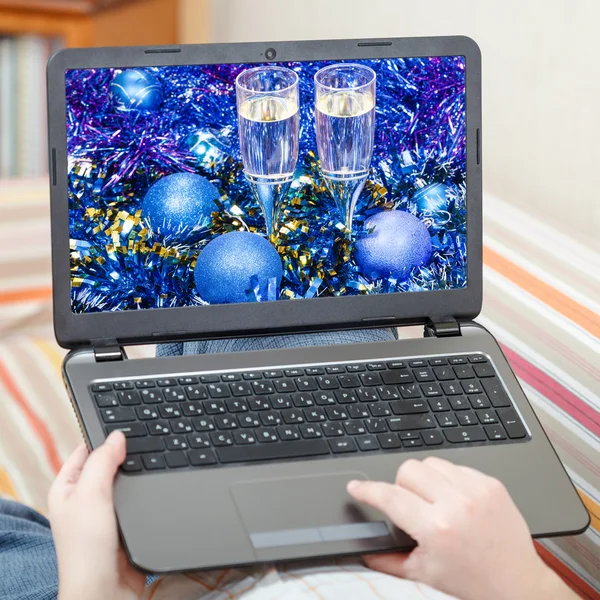 Man touches laptop with blue Xmas still life — 图库照片