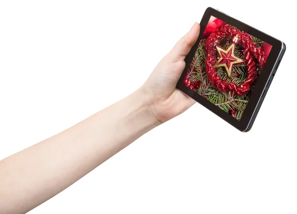 Hand hält Tablet-PC mit rotem Stern und Lametta — Stockfoto