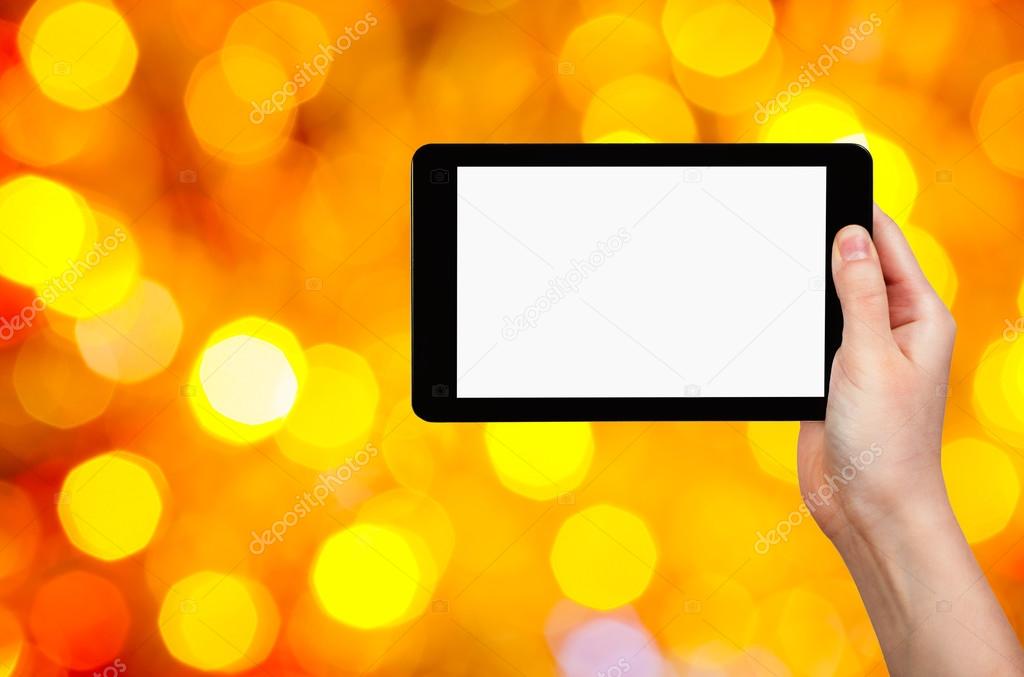 hand with tablet pc on yellow and red background