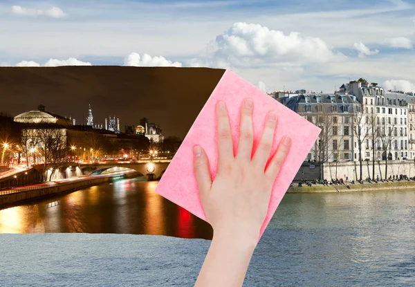 Рука стирает ночной вид Парижа розовой тканью — стоковое фото